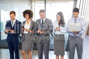 Businesspeople using mobile phone, lap top and digital tablet