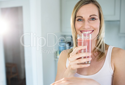 Pretty blonde woman holding her homemade smoothie