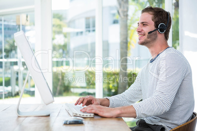 Handsome man working on computer with headset