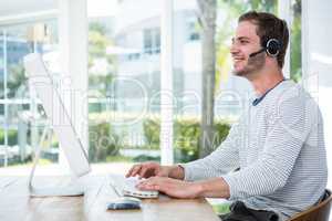 Handsome man working on computer with headset