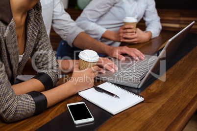 Close-up of friends using laptop