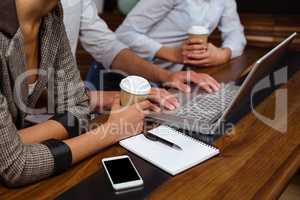 Close-up of friends using laptop