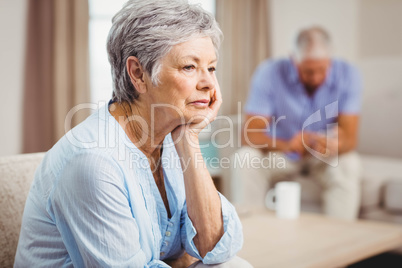 Worried senior woman sitting on sofa