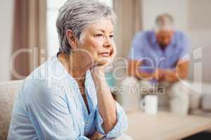 Worried senior woman sitting on sofa