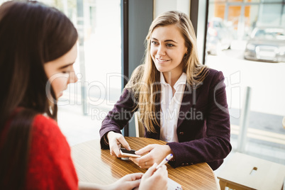 Cute blonde girl ordering from her friend