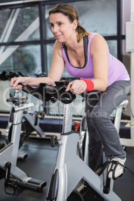 Smiling woman using exercise bike