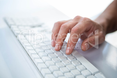 Close up view of a male hand typing on keyboard