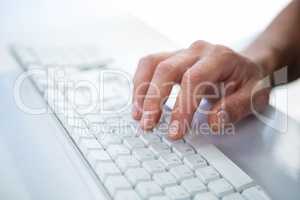 Close up view of a male hand typing on keyboard