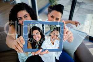Lesbian couple taking a selfie with digital tablet