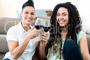 Lesbian couple toasting wine glasses