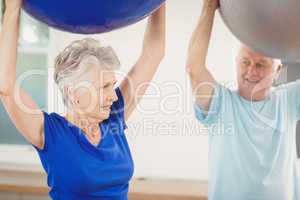 Senior couple exercising with exercise ball