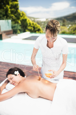 Woman receiving a honey massage from masseur