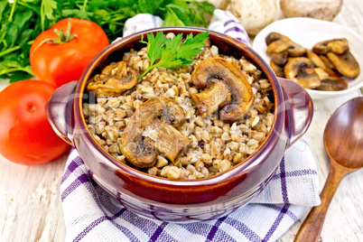 Buckwheat with champignons in clay bowl on napkin