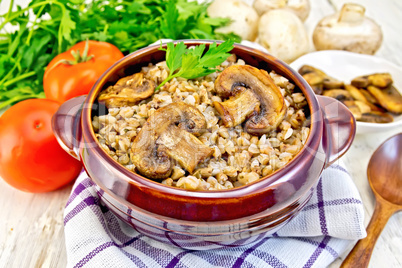 Buckwheat with champignons in clay bowl on towel