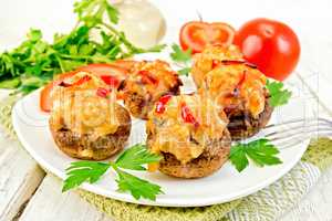 Champignons stuffed meat and pepper in white plate on board