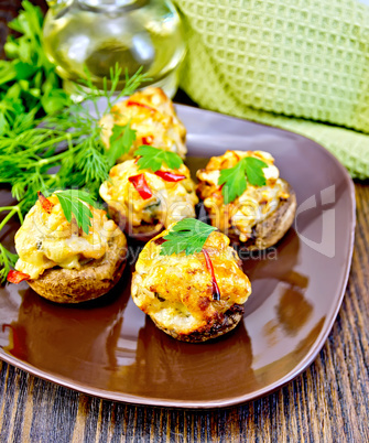 Champignons stuffed meat in brown plate on board