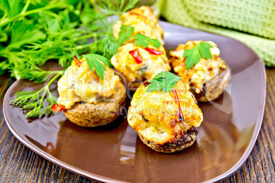 Champignons stuffed meat in brown plate on dark board