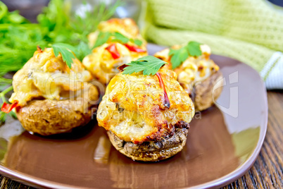 Champignons stuffed meat with parsley in brown plate on board