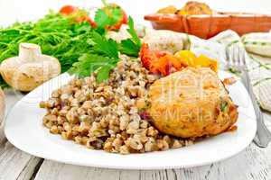 Cutlets of turkey with buckwheat and mushrooms in plate on board