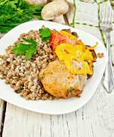 Cutlets of turkey with buckwheat and vegetables in plate on boar