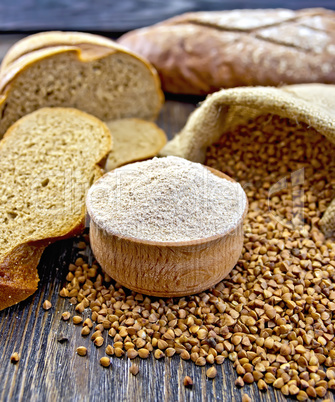 Flour buckwheat in bowl with cereals and breads on board