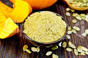 Flour pumpkin in bowl with seeds on board