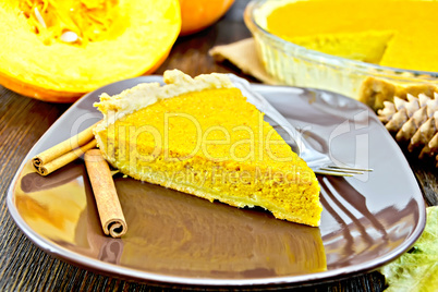 Pie pumpkin in brown plate on dark board