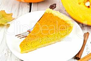 Pie pumpkin in plate with cinnamon on board