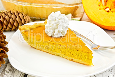 Pie pumpkin in plate with cream on light board