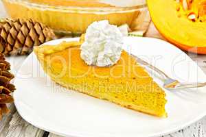 Pie pumpkin in plate with cream on light board