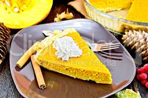 Pie pumpkin in plate with whipped cream on board