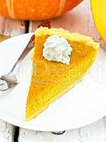 Pie pumpkin with whipped cream in plate on board