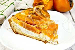 Pie with curd and persimmons in plate on board