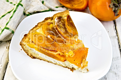 Pie with curd and persimmons in plate on light board