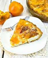 Pie with curd and persimmons in plate on napkin silicone