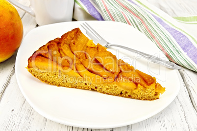 Pie with pears and honey in plate on light board