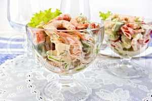 Salad with shrimp and tomatoes in glass on napkin