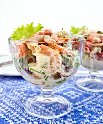 Salad with shrimp and tomatoes in glass on tablecloth