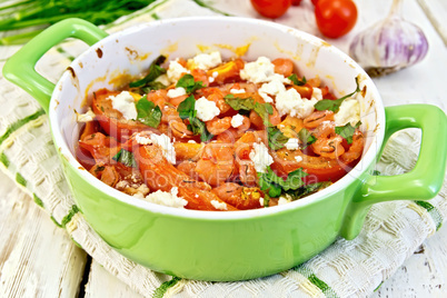 Shrimp and tomatoes with feta in pan on board