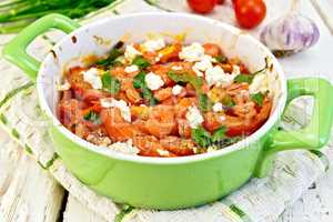 Shrimp and tomatoes with feta in pan on board