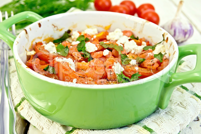 Shrimp and tomatoes with feta in pan on napkin