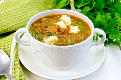 Soup lentil with spinach and cheese on board