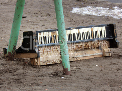 The broken piano keyboard, thrown in the yard