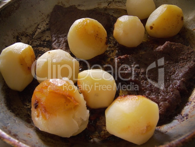 young potatoes and grilled meat in a skillet