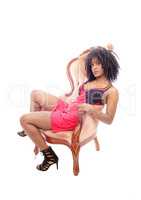 African American woman sitting in armchair.