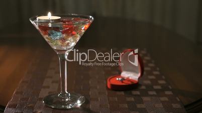 Burning candle in glass with precious stones