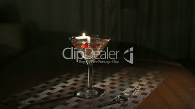 Extinguishing burning candle in glass