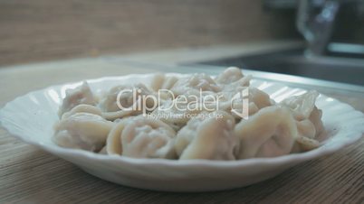 White plate of hot homemade dumplings on the table