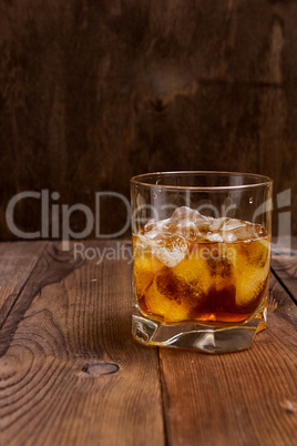 Faceted glass of whiskey with ice