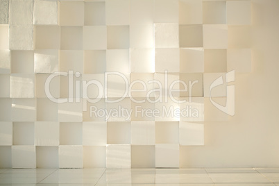 White painted concrete wall made of cubes with tiled floor